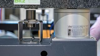 On the granite plate (top) stands a machine or testing system that is to be decoupled from vibrations. The inductive distance sensor (middle) continuously measures the distance to the granite plate (the target is a fixed steel disc). Supplied with these values, the controller quickly and precisely adjusts the level of the air spring (right). (Image: Baumer)