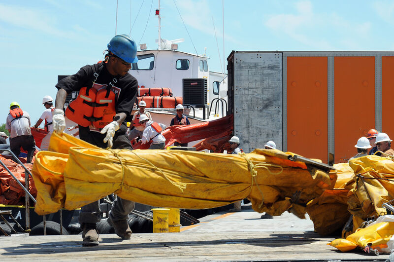 Environmental Services workers move oil containment boom onto a supply boat in Venice (Picture: US Coast Guard)