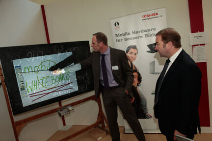 Martin Hümmecke (li) zeigt Ingram-Micro-Chef Gerhard Schulz, was das digitale Whiteboard im Klassenzimmer zu bieten hat. (Archiv: Vogel Business Media)