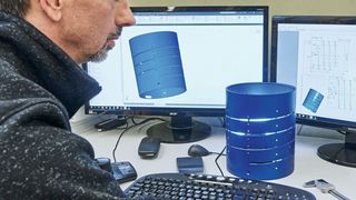 Der Konstrukteur Wilfried Berchtold mit dem Helix-Turm, der Trägerstruktur der Heizspirale für den neuartigen Gaschromatographen. (© Volker Lannert/Uni Bonn )