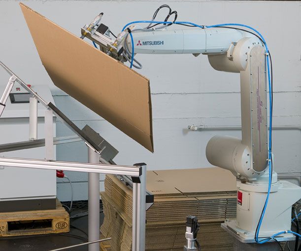 Der Roboter liefert den Versandkarton an und richtet ihn auf.  (Bild: Mitsubishi Electric)