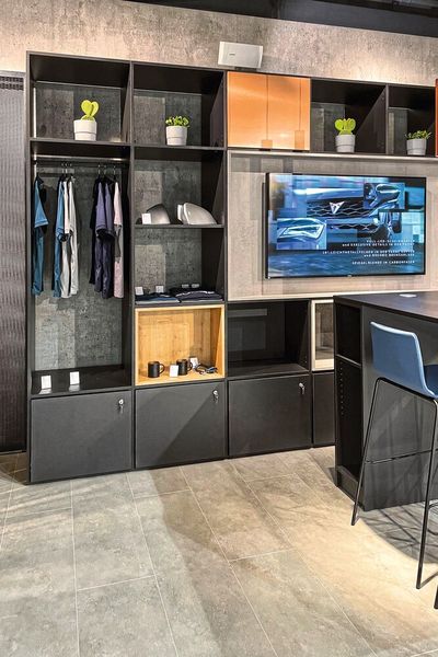 Accessoires neben Informationsbildschirm: Die Cupra-Garage erinnert mehr an einen Fan-Shop als an ein Autohaus. (Bild: Seat)