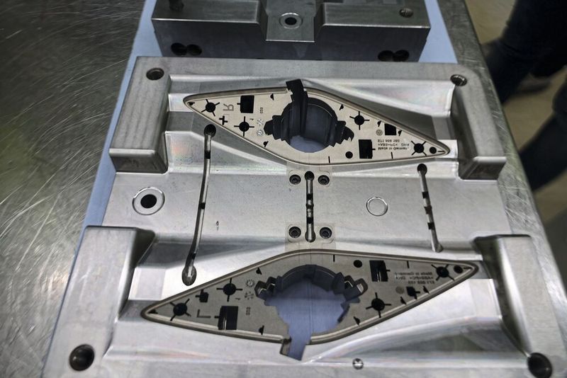 The back of the speaker grill — the sprue system of the four-cavity mould for left and right parts is clearly visible. The ejector set is mounted directly in the center.  (Source: Pergler Media)