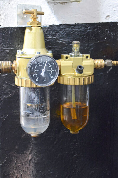Eine Druckluftwartungseinheit scheidet Kondenswasser ab und ölt Druckluftgeräte.  (Holz)