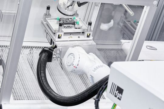 Für das vollständige Teilehandling sorgt ein KUKA Sechs-Achs-Roboter. Er entnimmt das Spritzteil aus dem Werkzeug und positioniert es präzise in einer Laserstation, wo das Bauteil mit einem Code beschriftet wird(Bild:  Arburg)