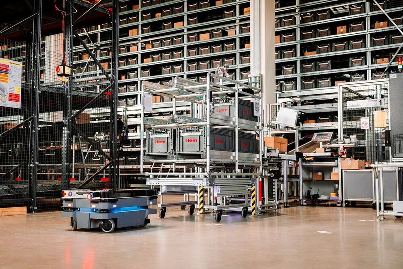 Der AMR Mir250 dockt einfach an das Item-Grundgestell an und bewegt es zum Zielort. Bestückt man den Base Carrier mit einem Regal, können auch mehrere KTL transportiert werden. (Bild: Item)