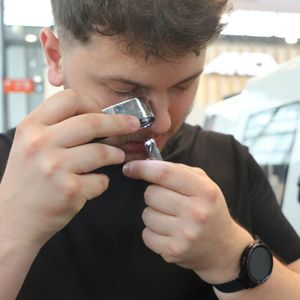 Der spätere Gewinner des Wettbewerbs Grinder of the year 2024, Osman Sylaj, kontrolliert hier genau seine schleiftechnische Arbeit mit der Lupe.(Bild:  KSKOMM)