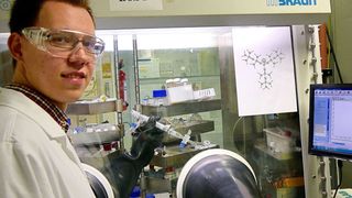 Der Marburger Chemiker Sebastian Ullrich präsentiert eine isolierte Probe seiner Superbase in einem Handschuhkasten, der mit Stickstoff als Schutzgas gefüllt ist. (Jörg Sundermeyer)