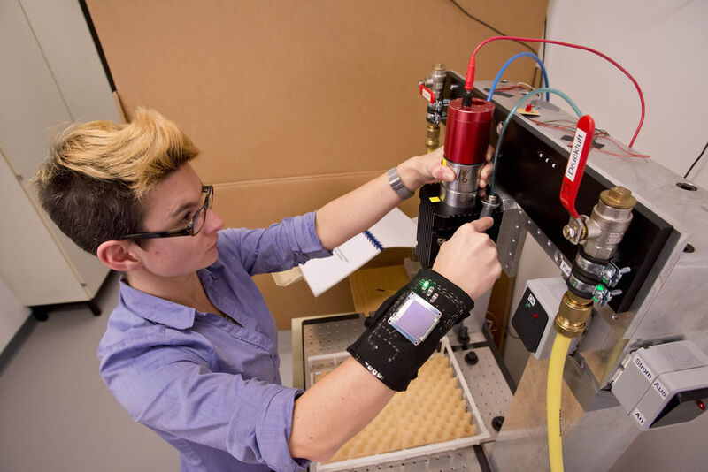 Beim Wechsel einer Spindel in einer Mikrofräsmaschine testet Ulrike Schmuntzsch im TU-Labor die Warnmanschette. (Bild: TU Berlin/PR/Ulrich Dahl)