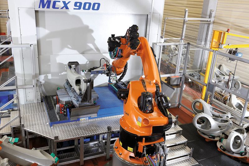 Bild 3: Das aus der Maschine kommende Bauteil entgratet der Roboter. Dazu wechselt er den Greifer gegen eine Bearbeitungsspindel. (Bild: Kuka)