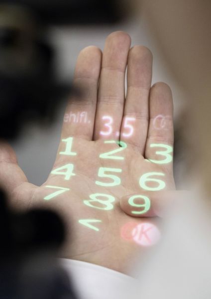 Mit der Hand-Projektion können beispielsweise Vorgaben wie „Ölstand prüfen“ auf die Handfläche projiziert werden. (Audi AG)