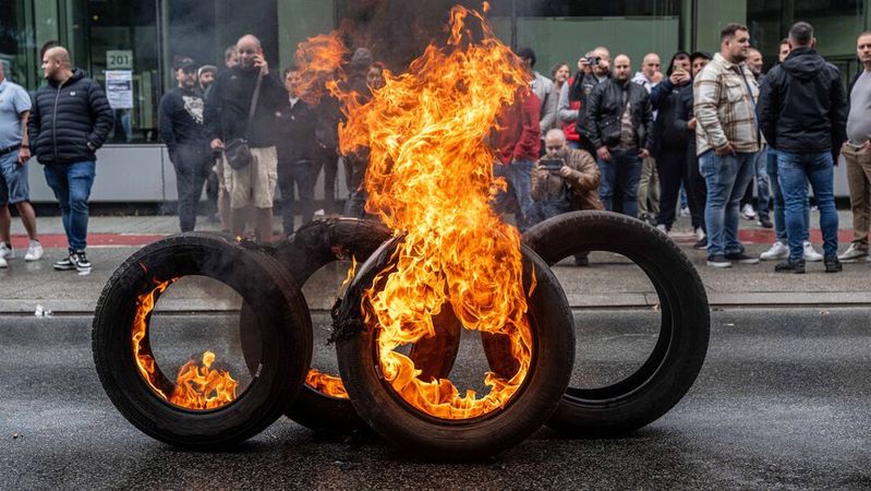 Am Montag haben Audi-Mitarbeiter aus Protest gegen die drohende Werksschließung vor dem Eingang des Brüsseler Standortes Reifen angezündet.(Bild:  picture alliance/dpa/Belga)