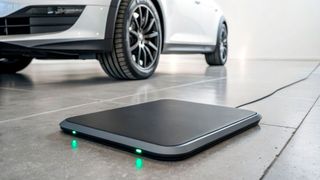 Symbolic image: A retrofitted EV charges wirelessly via the ground-embedded coil, with the charging process starting automatically once the vehicle is positioned correctly. (Source: © Johnnii - stock.adobe.com)
