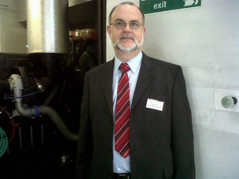 Das ist der Chef von Active Power, Uwe Schrader-Hausmann, vor dem Generator seines USV-Containers - ein Motor, wie er etwa in LKWs eingebaut wird. Bild: uo (Archiv: Vogel Business Media)