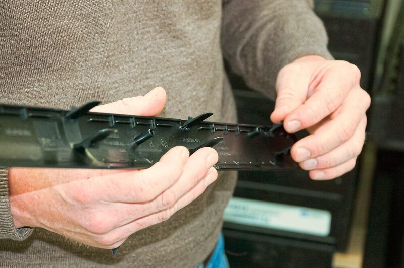 Matthias Wagner begutachtet ein mit Kunststoff hinterspritztes Aluminiumteil, das als Einstiegsleiste für die BMW-7er-Reihe direkt ans Band geliefert wird.  (Erbiwa/Mecadat)