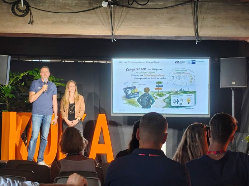 ... diskutierten Dr. Christian Fischer, Abteilungsleiter Ausbildung bei der IHK Schwaben, und Dr. Marietta Menner, Leiterin des KI-Bildungsprogramms am Center for Future Production der Universität Augsburg, darüber, wie Künstliche Intelligenz in der Produktion eingesetzt werden kann und welche Rolle Aus- und Weiterbildung dabei spielen. Im Mittelpunkt stand die Frage, wie die IHK Schwaben und das Center for Future Production Unternehmen fit für die Zukunft machen. (Bild: © Serina Sonsalla)