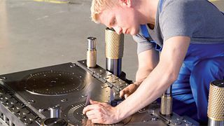 Ein Werkzeugmacher bei der Endkontrolle vor dem Zusammensetzen von Werkzeugober und-unterteil. Die Elektromobilität bringt neue Anforderungen auch für den Werkzeugbau. (Foto: Aweba)