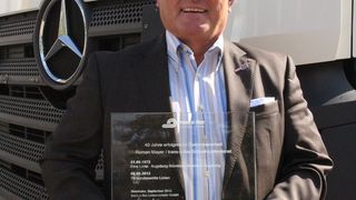 Vor einer seiner neuesten Sattelzugmaschinen mit Euro-6-Motor präsentiert Roman Mayer einen Gedenkstein von Trans-O-Flex als Dank für die langjährige gute Zusammenarbeit. (Bild: Trans-o-flex)