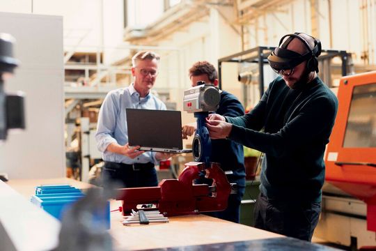 Mit Avikom komme ein bisher einzigartiges audiovisuelles Assistenzsystem für Montage- und Logistikarbeiten ins industrielle Umfeld. Hier montiert einer der Entwickler mit virtueller Hilfe eine Absperrklappe fehlerfrei. Über die Datenbrille und das Headset erhält er die entsprechenden Anweisungen, heißt es. Lesen Sie hier, warum das Ganze etwas Besonderes ist.(Bild:  P. Pollmeier / FH Bielefeld)