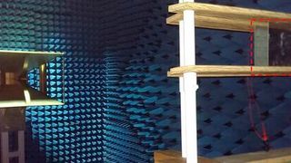 The researchers tested their metamaterial-based antenna in an anechoic chamber. The radio wave is sent out from the horn antenna on the left and received by the metasurface antenna mounted on the wood frame on the right. (Jiangfeng Zhou and Clayton Fowler)