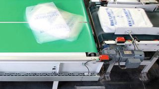 Durch unterschiedliche Geschwindigkeiten der Förderbänder und das Eigengewicht selbst wird der gefüllte Sack mit der neuen Doppelbanddrehvorrichtung gedreht. (Bild: Beumer)