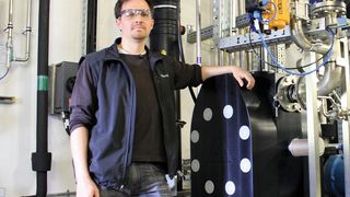 Florian Habeck, Assistant Tank Manager bei Roche Diagnostics mit der der Druckluftmembranpumpe (Baureihe E80), die im  Werk liebevoll „Dicke Bertha“ genannt wird. Lösungsmittelförderung ist mit der ex-sicheren Pumpe kein Problem. (Bild: Almatec)