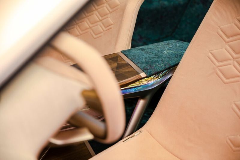 Zwischen den Sitzen spannt sich eine scheinbar schwebende und kaffeetischähnliche Mittelkonsole, unter deren Holzfurnier sich „unsichtbar“ ein Touch-Pad befindet. (Bild: BMW)
