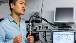 Doktorand Hang Zhang steht vor dem Mikroskop, mit dem er winzige Gel-Strukturen untersucht, die sich wie kleine Roboter selbstständig im Wasser bewegen können. (©Philipp Scheffler, DWI)