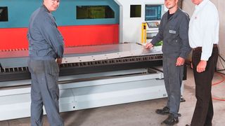Knuth-Verkaufsleiter Christian Busch (rechts) mit zwei Kitzinger-Spezialisten, die Blechkomponenten aus der aktuellen Produktion präsentieren, die mit der D.Laser MT 3015/FL 3000 geschnitten wurden. (Knuth)