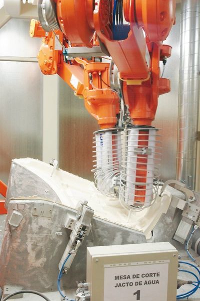 Bild 3: Den komplexen 3D-Beschnitt des Innendeckels übernehmen die von zwei hängend montierten Robotern geführten Schneiddüsen der KMT-Hochdruckwasserstrahl-Schneidanlage. Bilder: ABB (Archiv: Vogel Business Media)