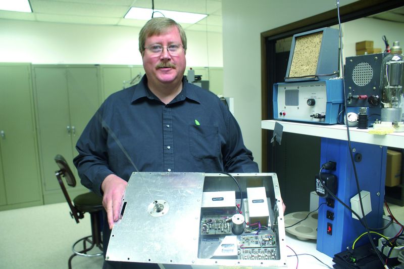 50 Jahre Amateurfunk im Weltraum: Am 12. Dezember 1961 startete der erste von Funkamateuren konstruierte Satellit OSCAR 1 mit einer Thor Agena B Trägerrakete von der kalifornischen US-Luftwaffenbasis Vandenberg in den Orbit. Das 30 cm x 25 cm x 12 cm kleine „Orbiting Satellite Carrying Amateur Radio“ mit einer Masse von 4,5 kg sendete über eine 60 cm lange Monopolantenne und umkreiste die Erde in rund 431 km Höhe. Die Kosten hielten sich dank zahlreicher Materialspenden aus den ganzen USA in Grenzen: Das Projektteam musste gerade einmal 68 US-$ aufbringen. Gespeist wurde der Sender von drei 18-Volt-Batterien und sendete bis zum 2. Januar 1962 mit einer Leistung von 140 mW auf 145 MHz im Morsecode „HI“. Die Anzahl der gesendeten HIs pro Minute gab Auskunft über die herrschende Temperatur im Inneren des Satelliten. Im Bild Testingenieur Bob Allison (WB1GCM) von der American Radio Relay League (ARRL) mit einem Nachbau des ersten Amateurfunksatelliten. // TK (Archiv: Vogel Business Media)