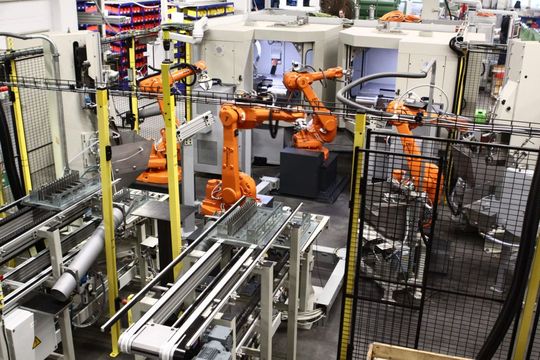 Roboterzelle mit drei Bandschleifstationen, einem Handlings- und Bearbeitungsroboter und einem Magazinsystem zur Bearbeitung von Küchenmessern.(Bild:  Heinz Berger Maschinenfabrik GmbH & Co. KG)