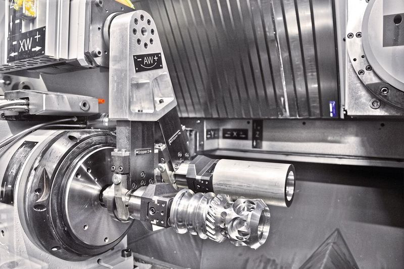 Ein wesentliche Bausteine für die Wirtschaftlichkeit der HSTM 150 HD von Hamuel sind ihr Werkstück- und Werkzeugwechsler. Auch das Drehen beherrscht diese Hybridmaschine. Hier ein Blick auf ihren Doppelgreifer bei der Arbeit. Rund um die Uhr und mannlos könne das System arbeiten. (Hamuel)