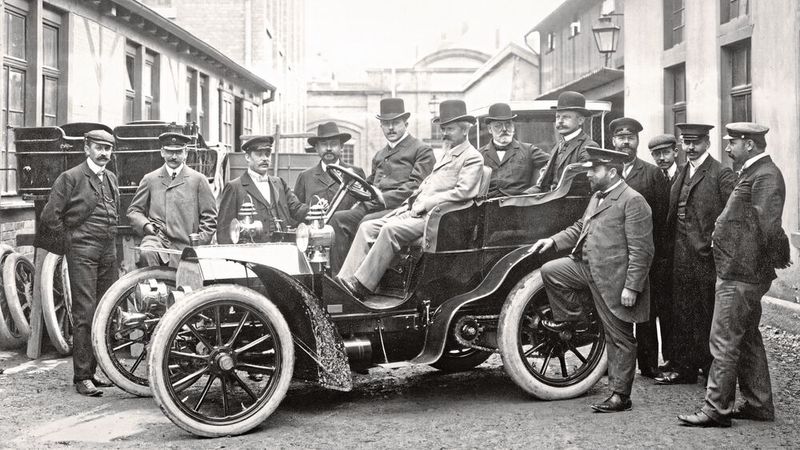 Wilhelm Maybach, vorn auf dem Beifahrersitz eines Mercedes-Simplex 18/22 PS im Jahr 1903 im Fabrikhof des Cannstatter Werks der Daimler-Motoren-Gesellschaft. Er gilt als einer der größten Erfinder im Automobil- bzw. Motorenbau. Wilhelm Maybach, vorn auf dem Beifahrersitz eines Mercedes-Simplex 18/22 PS im Jahr 1903 im Fabrikhof des Cannstatter Werks der Daimler-Motoren-Gesellschaft. Er gilt als einer der größten Erfinder im Automobil- bzw. Motorenbau.