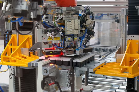 Die Stacking-Anlage der Referenzfabrik.H2: Hubeinheit für Stapel (orange), Werkstückträger mit Führungen (Mitte), Transfersystem, Greifer mit Fließsauger, Abstreifer und zwei Kameras zur Lagekorrektur.(Bild:  Fraunhofer IWU)