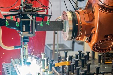 Versuchsaufbau mit robotergeführter Bolzenschweißanlage und ringförmig angeordnetem Mikrofonarray. So können die charakteristische Prozessakustik erfasst und Trainingsdaten für die KI-gestützte Qualitätsbewertung gewonnen werden.  (Bild: Fraunhofer IDMT)