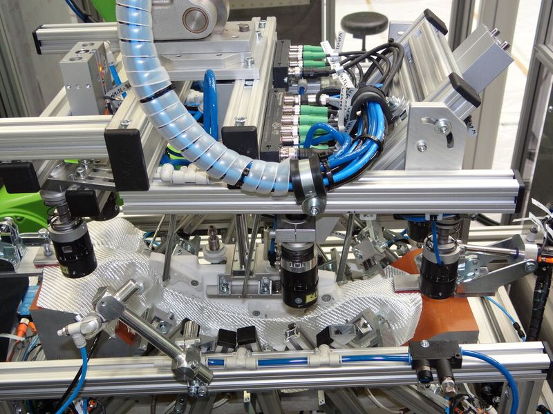 Ablegen und Fixieren von texilen Zuschnitten im Preformwerkzeug. Aus dem vorgeformten Faserzuschnitten (Preform) entsteht das Mittelstück eines Bremspedals. (Bild: Engel)