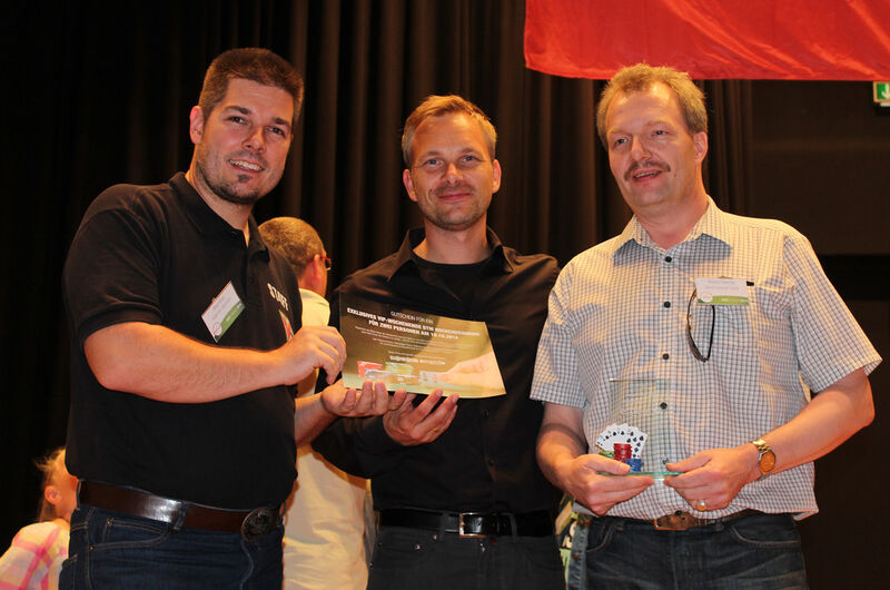 Roland Diercks (Space Computer, rechts im Bild) gewann die Casino-Night im Schloss. Mike Ritter (Kaspersky, links) und André Vogtschmidt überreichten ihm als Preis zwei VIP-Tickets zur DTM am Hockenheimring. Gesponsert wurden die Tickets von Kaspersky. (Bild: Emendo)