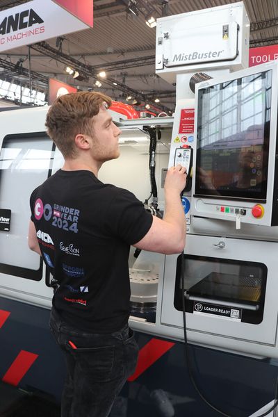 Die gespannten Blicke des Publikums im Genick, macht sich Jan-Niclas Kiefer von Effgen Lapport Schleiftechnik beim Wettbewerb Grinder of the year 2024 dennoch cool ans Werk, um den gewünschten Fräser präzise mit der FX7 Ultra von Anca zu fertigen. (Bild: KSKOMM)