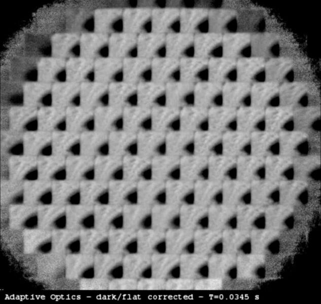 Screenshot einer Videosequenz: Das vom Shack-Hartmann Wellenfrontsensor erzeugte Bild, aufgenommen von der Eosens CL High-Speed Kamera. Es ist deutlich zu sehen, wie die Mikrolinsen die Austrittspupille des Teleskops in 85 Einzelbilder aufteilt. Jedes Video besteht aus 1.000 Einzelbildern. Die Aufnahmegeschwindigkeit der Kamera beträgt 2.000 fps (2 kHz). Das Teleskop wurde leicht seitlich zu einem Sonnenfleck ausgerichtet, der als schwarzer Fleck auf den Teilbildern zu sehen ist. Das Video wurde von der Software der adaptiven Optik korrigiert. Ein dunkles Feld wurde subtrahiert, ein flaches Feld wurde ausdividiert und der Kontrast wurde um den Faktor 4 erhöht. (Bild: Mikrotron)
