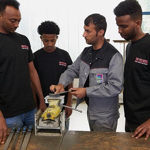 Flüchtlinge erfolgreich integrieren: Khaibar Fatehzada (m.), der dank des Projekts der Friedhelm Loh Group im vergangenen Jahr seine Ausbildung bei Rittal beginnen konnte, hilft jetzt seinen neuen Kollegen beim Einstieg in die Arbeitswelt der Industrie.(Bild:  Friedhelm Loh Group/Rittal)