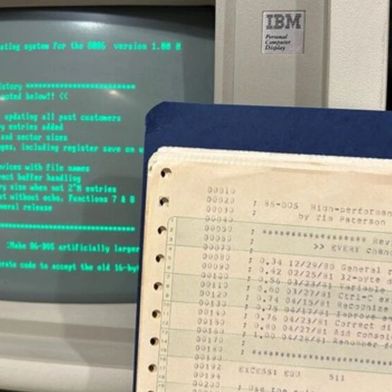 Ein früher IBM-PC, nebst einem Teil der Ausdrucke, die den Quellcode zu x86-DOS enthalten. (Bild: Rich Cini, Microsoft)