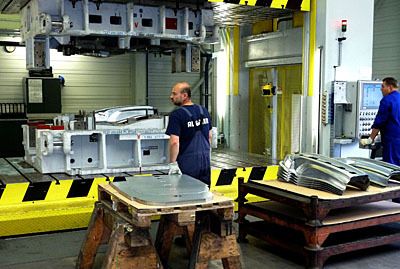 Vorne links ist der Stapel mit den vorgeschnittenen Platinen zu erkennen. Rechts sind die fertig umgeformten Bauteile übereinander gestapelt. (Archiv: Vogel Business Media)