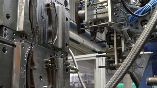 Das Bild zeigt den Blick in die 2K-Spritzgießmaschine mit robotergestützter Entnahme. (Bild: Weiss)