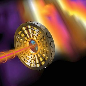 Illustration des Detektorrings: Ultrakurze Röntgenpulse (rosa) ionisieren Neongas im Zentrum des Rings. Ein Infrarotlaser (orange) lenkt die Elektronen (blau) auf ihrem Weg zu den Detektoren ab.