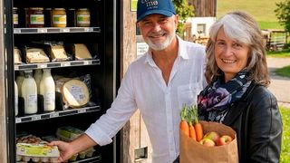 Andreas Schubert, der im Juni 2025 im Alter von 61 Jahren die Plattform Kiosk Scout gründete, zusammen mit einer Kundin an einem Verkaufsautomaten. (Bild: Kiosk Scout)