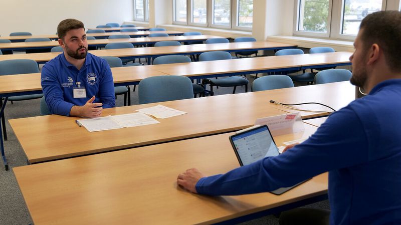 Maximilian Kopp aus dem Saarland erläutert Prüfer Diego Delano Campos, wie ein Kfz-Betrieb vorgehen sollte, wenn die Reparatur eines Fahrzeugs schon mehrfach fehlgeschlagen ist. (Bild: Schmidt – autoFACHMANN)