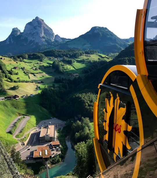 Die Standseilbahn Schwyz-Stoos auf der Bahnstrecke. Die fassförmigen Kabinen mit automatischen Niveauregulierung ermöglichen, dass die Fahrgäste stets auf einer waagrechten Fläche stehen, während sich die Bahn fast senkrecht die Wand hochschiebt.(Bild:  Stoosbahnen AG, Luca Küng)