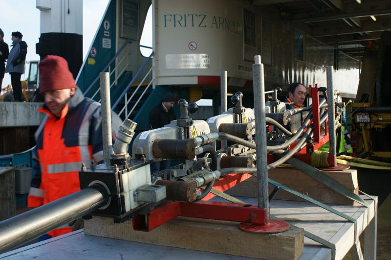 Die Feuerwehrschläuche, die zur Befestigung des Werkstisches dienen, führen zu dem Lastwagen der Kabelfirma Nexans, der die Kabeltrommel Huckepack trägt. Das Verlegeteam ist aus verschiedenen Nationalitäten gemischt.  (Archiv: Vogel Business Media)