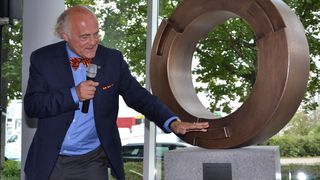 Wort- und Gestenreich erläutert Klaus Endress die Bedeutung der als Eingweihungsgeschenk mitgebrachten Skulptur. So soll der metallene Reifen montiert auf lokal vorkommendem Felsgestein die Verbundenheit mit dem Standort und Loyalität im Unternehmen und dem Unternehmensverbund symbolisieren. (Bid: PROCESS) (Archiv: Vogel Business Media)